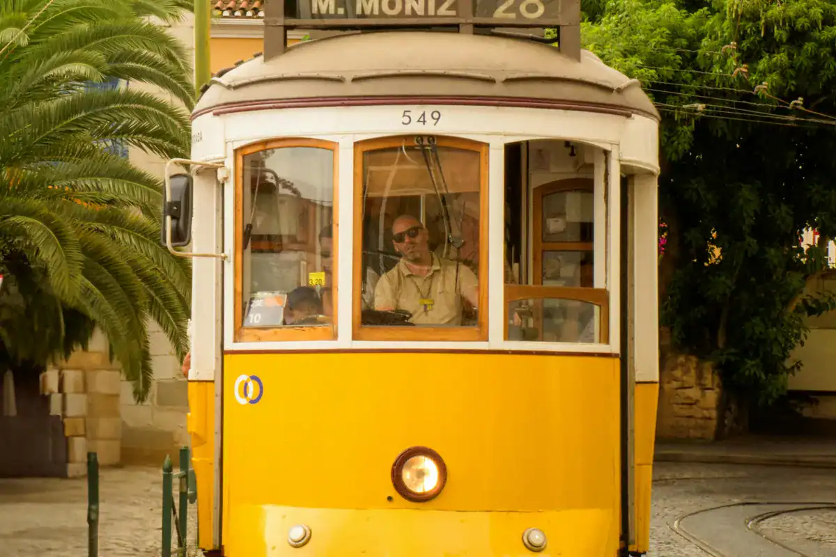 Historische gele tram 28 met bestemming Martim Moniz op kasseien