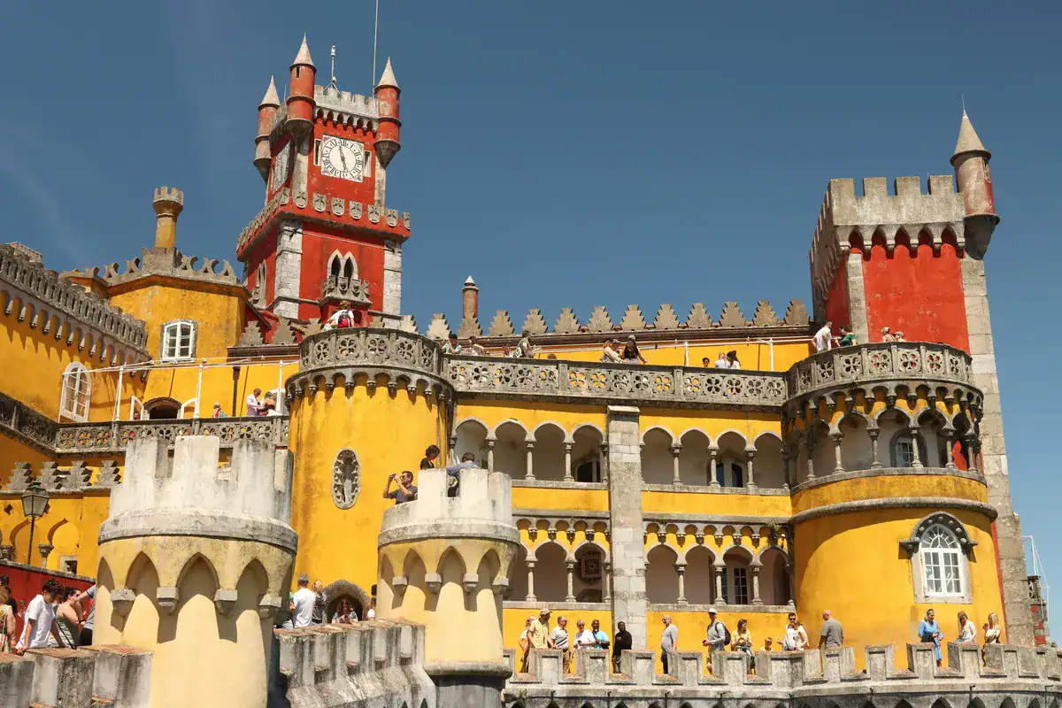 Besucher erkunden den bunten Innenhof des Palácio da Pena in Sintra